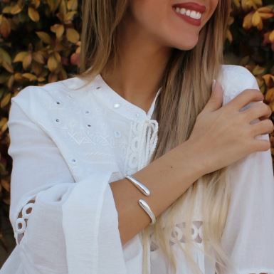 mujer sonriendo mostrando sus joyas de plata de ley para mujer